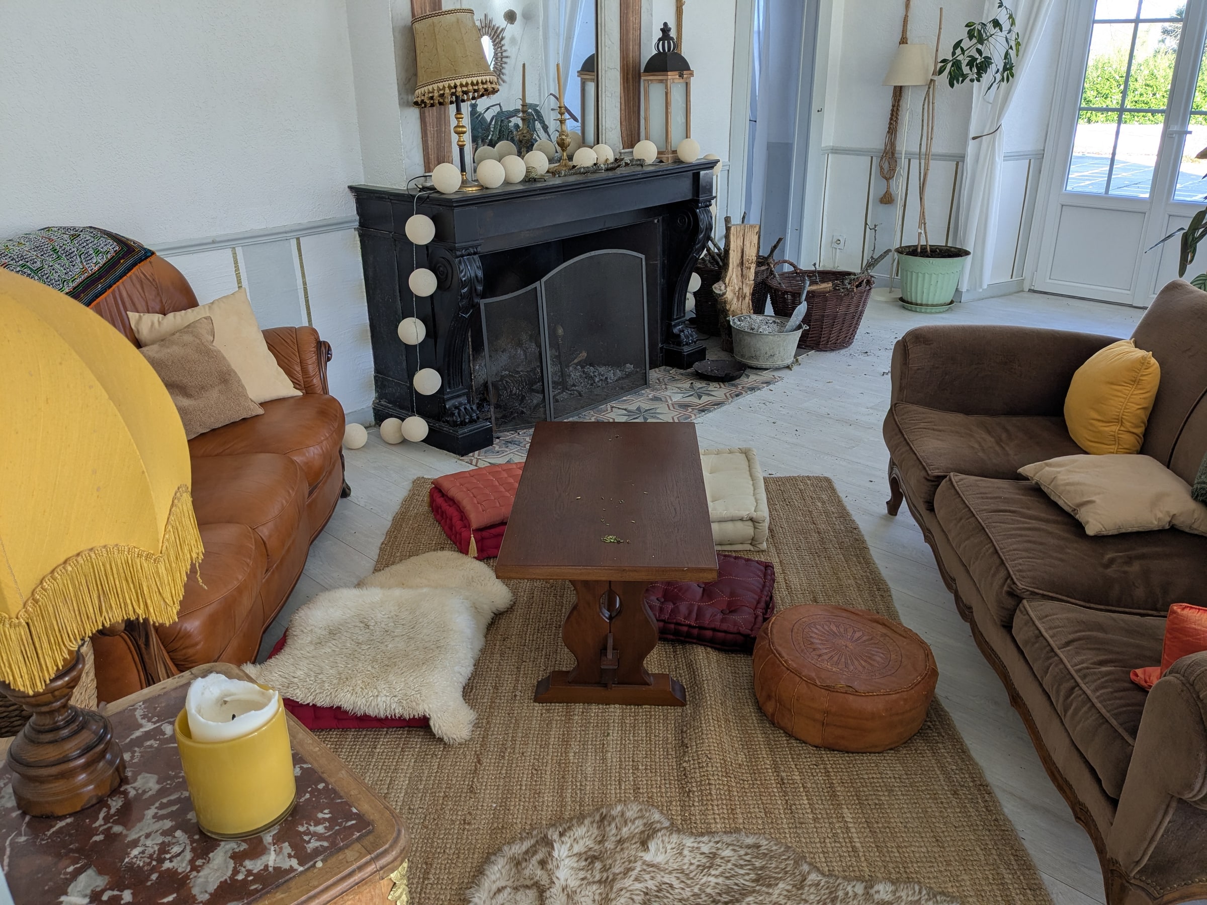 A sitting room with a fireplace and floor cushions